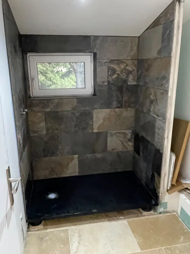 Douche à l'italienne en carreaux effet ardoise, sol en pierre claire.