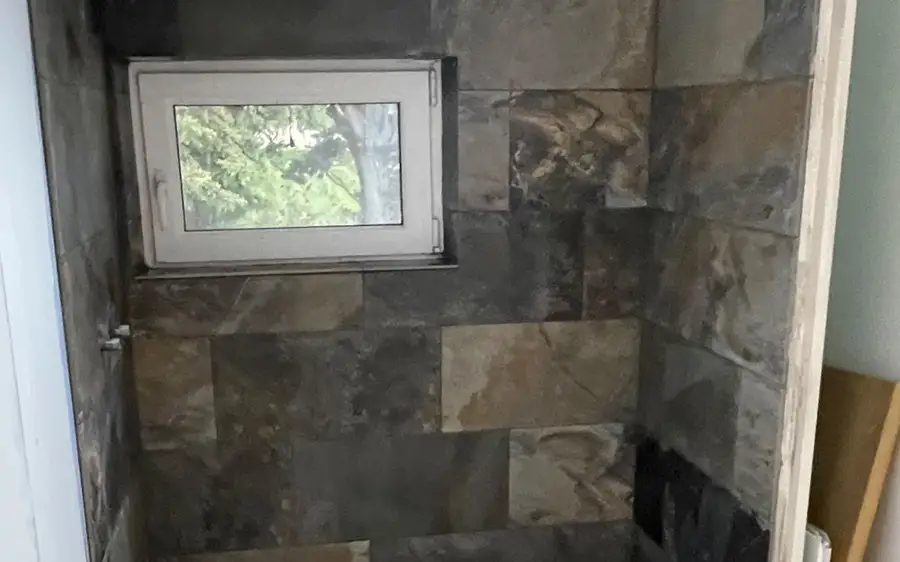 Douche à l'italienne en carreaux effet ardoise, sol en pierre claire.