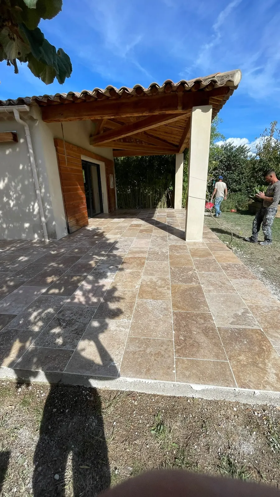 Terrasse en dallage pierre devant un pool house.